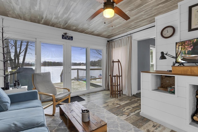 living room with wood ceiling, dark wood-style flooring, a ceiling fan, and a water view