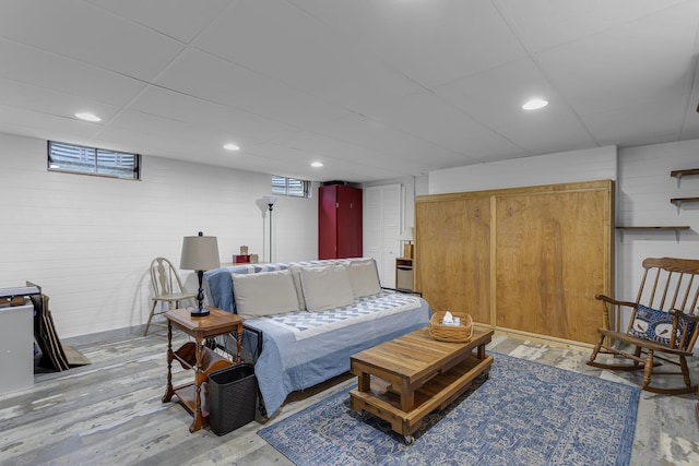 living area featuring light wood finished floors, a drop ceiling, and recessed lighting