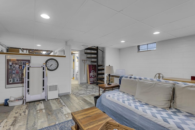 bedroom with recessed lighting, a paneled ceiling, and wood finished floors