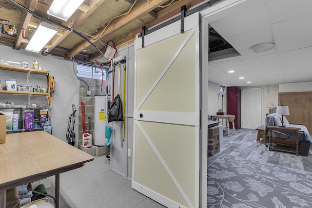 basement featuring a barn door and water heater