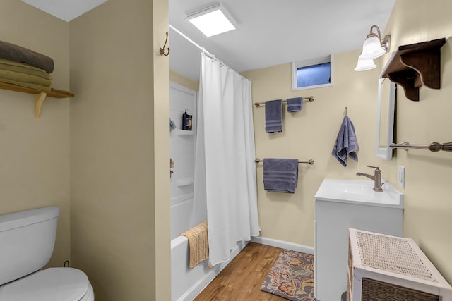 full bathroom featuring vanity, toilet, wood finished floors, shower / bath combo with shower curtain, and baseboards