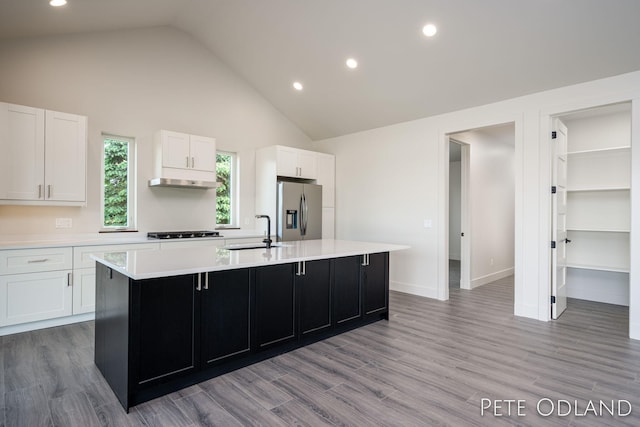 kitchen with hardwood / wood-style floors, an island with sink, white cabinetry, sink, and stainless steel appliances