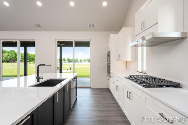 kitchen featuring dark wood-type flooring, sink, white cabinetry, stainless steel gas stovetop, and beverage cooler