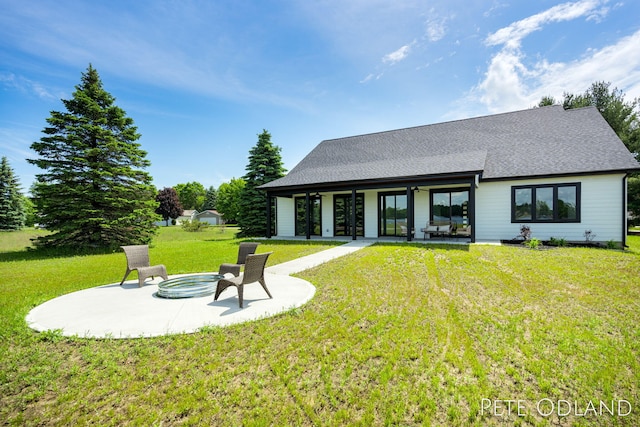 rear view of house featuring a yard, a patio area, and a hot tub