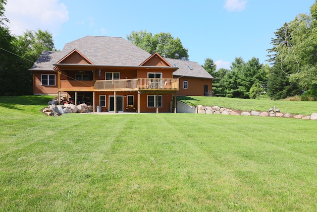 rear view of house with a deck and a lawn