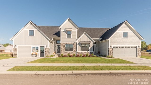 craftsman inspired home with a garage and a front lawn