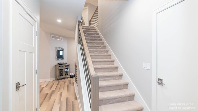 stairs featuring hardwood / wood-style floors