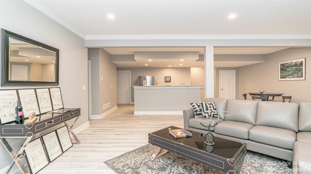 living room with crown molding and light hardwood / wood-style flooring