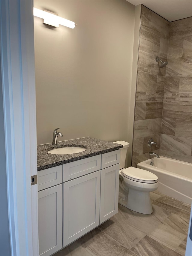 full bathroom with vanity, tiled shower / bath combo, and toilet