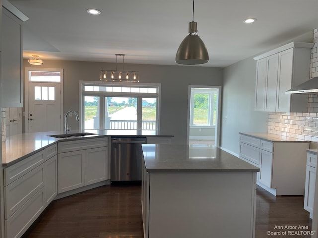 kitchen featuring sink, tasteful backsplash, stainless steel dishwasher, a kitchen island with sink, and white cabinets