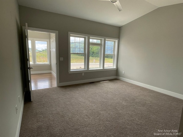 spare room with vaulted ceiling, carpet floors, and ceiling fan