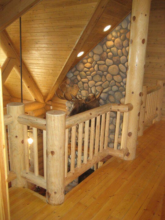 interior space featuring beam ceiling, wood finished floors, wooden ceiling, and log walls