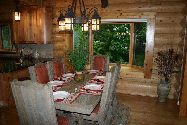 dining area with rustic walls and wood finished floors