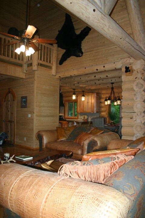 bedroom featuring beam ceiling, rustic walls, and a towering ceiling