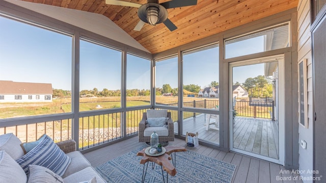 sunroom / solarium featuring lofted ceiling, ceiling fan, wooden ceiling, and a healthy amount of sunlight