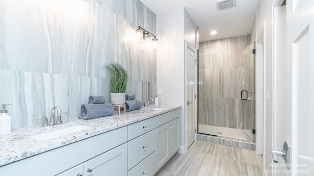 bathroom featuring vanity, tile walls, and a shower with shower door