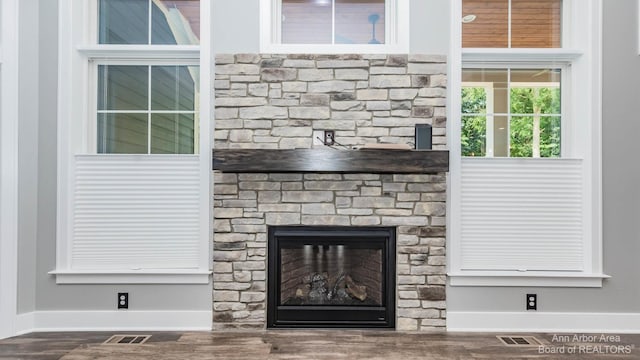 interior details featuring a fireplace and wood-type flooring