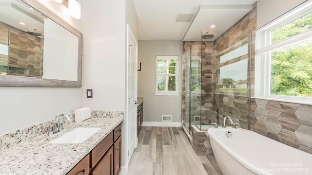 bathroom with vanity, hardwood / wood-style flooring, a wealth of natural light, and separate shower and tub