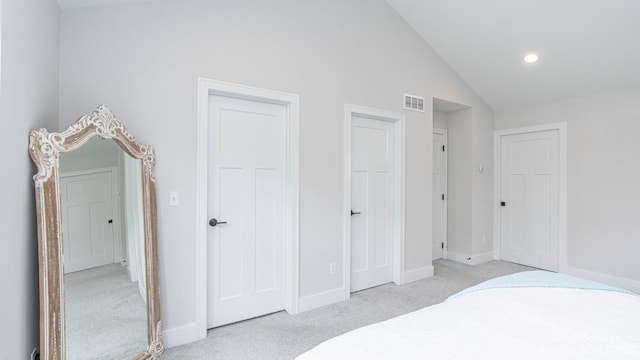 carpeted bedroom with lofted ceiling