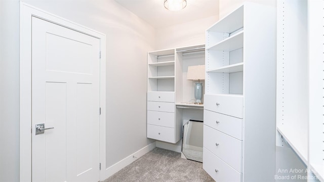 walk in closet featuring light carpet