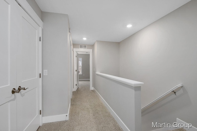 hallway featuring light colored carpet