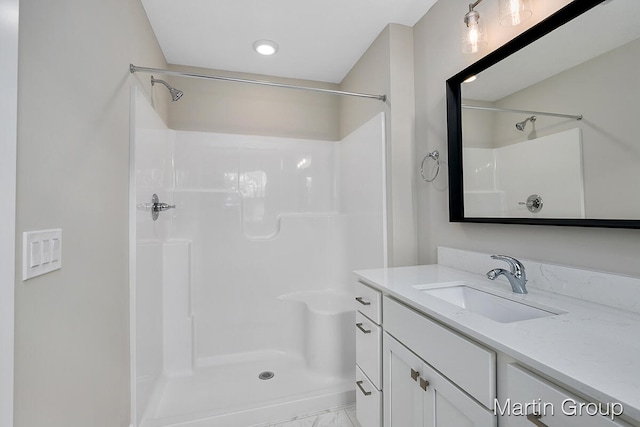 bathroom with walk in shower and vanity