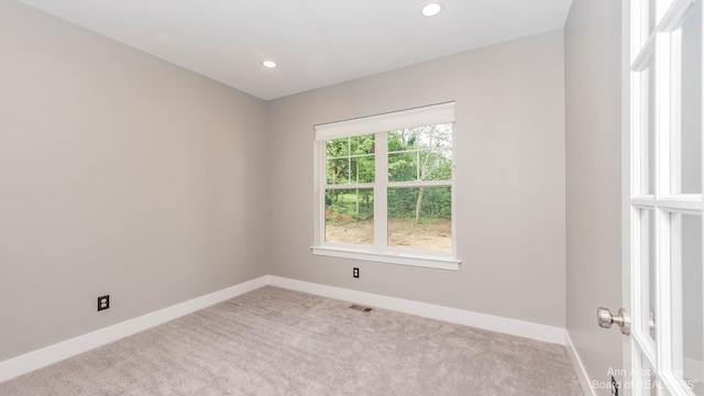 unfurnished room featuring light carpet