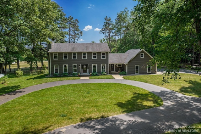 colonial-style house featuring a front yard