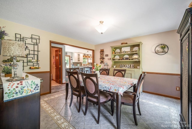 tiled dining space with a textured ceiling