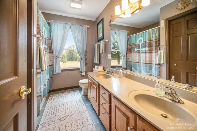 bathroom featuring toilet, vanity, and tile patterned flooring