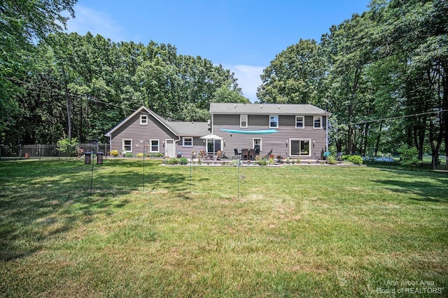 rear view of property featuring a lawn and a patio