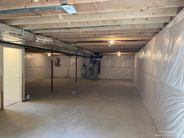 basement featuring electric panel and heating unit