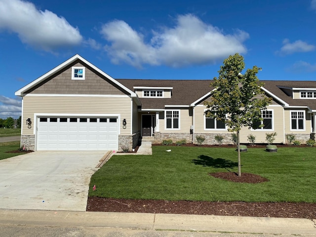 craftsman house with a garage and a front lawn