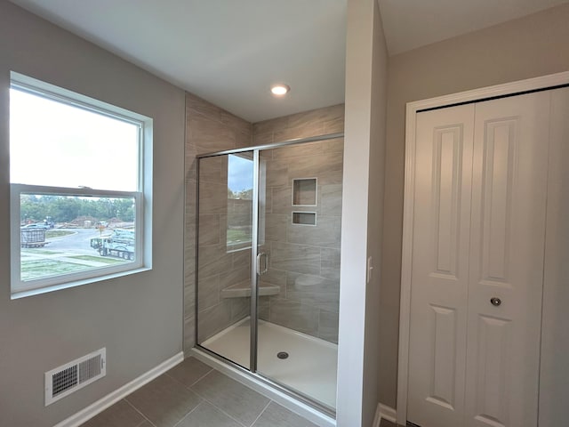 bathroom featuring tile patterned flooring and an enclosed shower