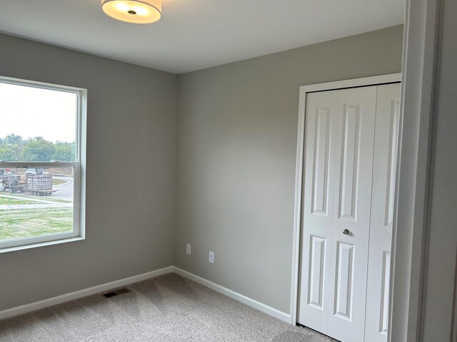 unfurnished bedroom with carpet flooring and a closet