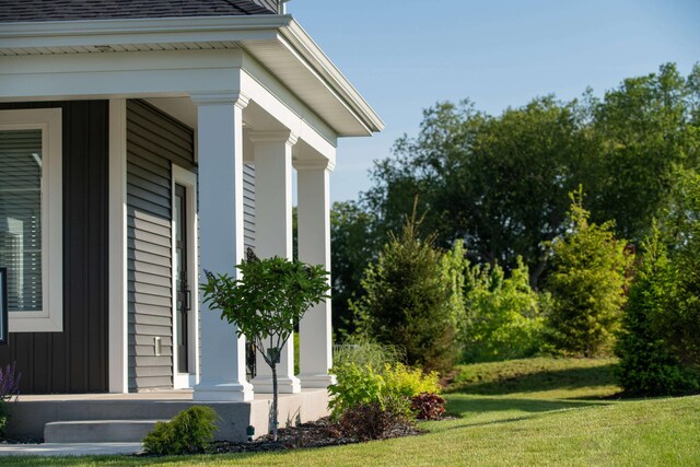 view of side of home with a lawn and covered porch