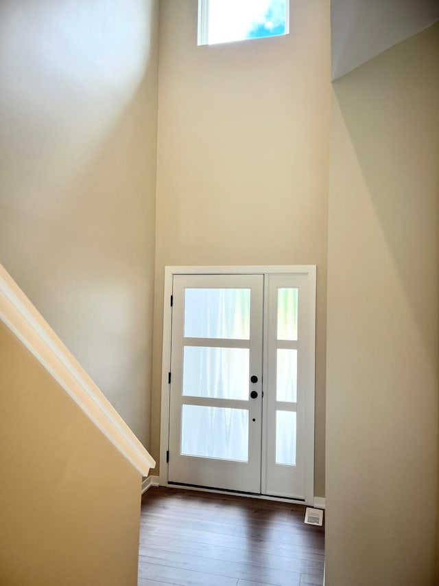 entryway with a towering ceiling and hardwood / wood-style flooring