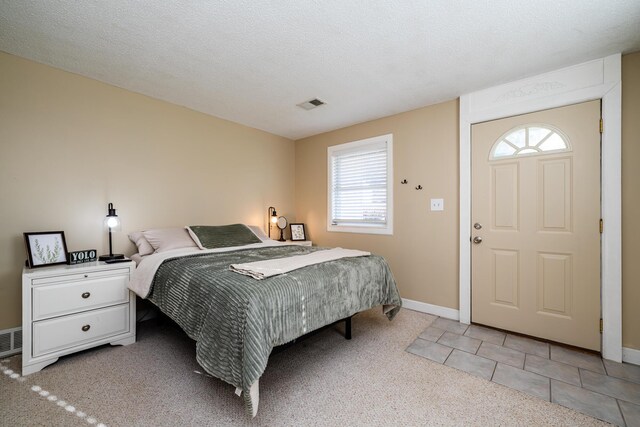 carpeted bedroom featuring multiple windows and a textured ceiling