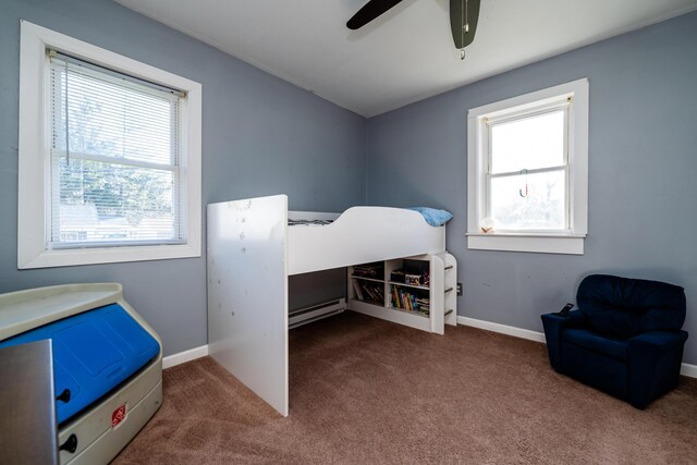 carpeted bedroom with ceiling fan and a baseboard radiator