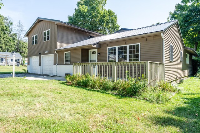 back of house with a yard and a garage