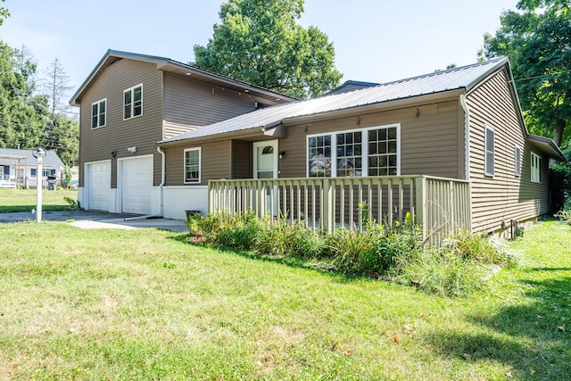 view of front of property featuring metal roof, an attached garage, and a front lawn