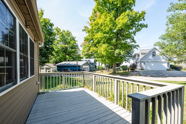 wooden terrace with a yard and a garage