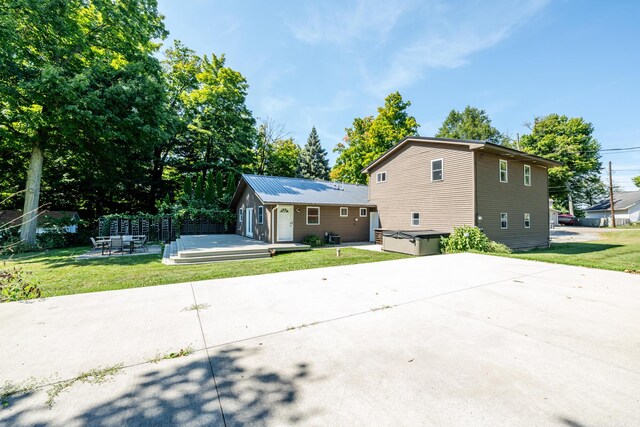 back of property featuring a yard and a patio