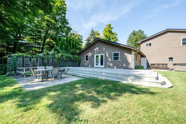 rear view of property featuring a lawn, french doors, a wooden deck, and fence