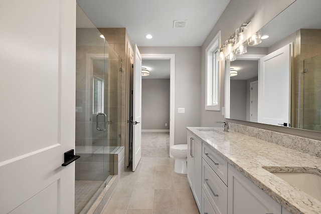 bathroom featuring vanity, toilet, a shower with shower door, and tile patterned flooring