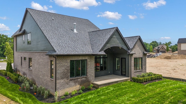 rear view of property with a yard and a patio area