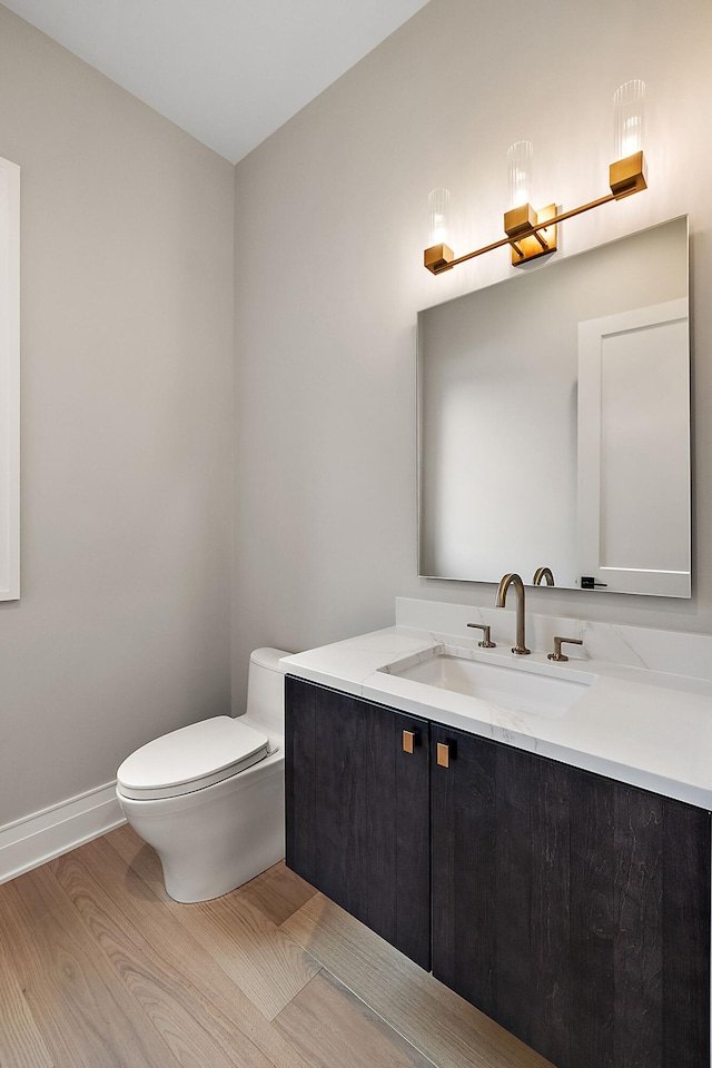 bathroom featuring hardwood / wood-style flooring, vanity, and toilet