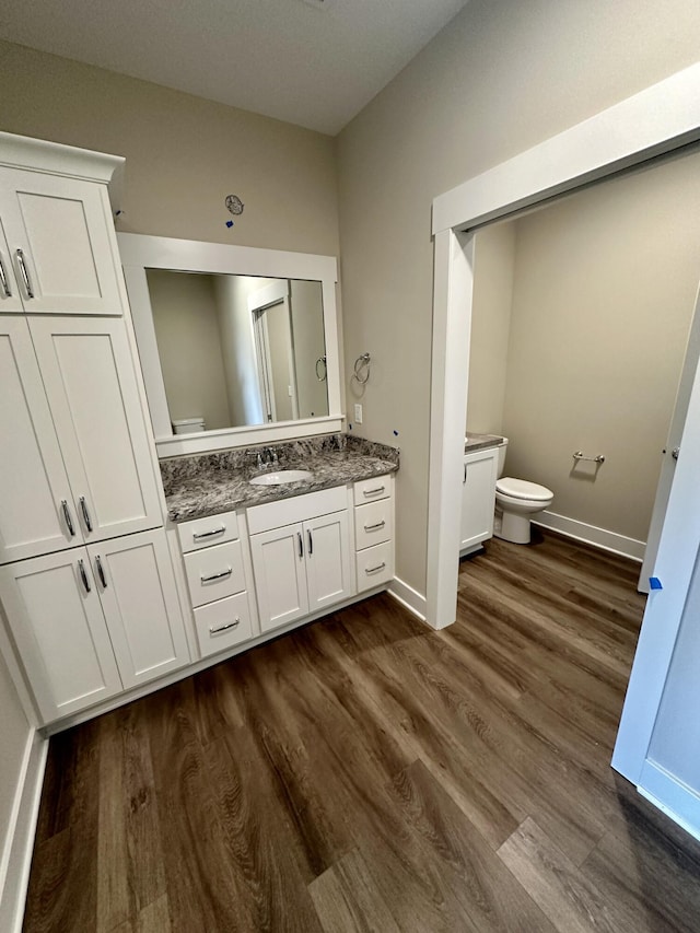 bathroom with hardwood / wood-style flooring, vanity, and toilet