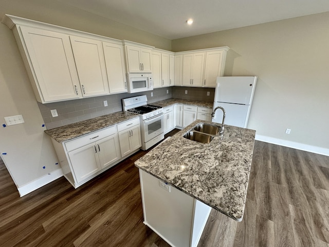 kitchen featuring sink, white cabinets, white appliances, a kitchen island with sink, and backsplash