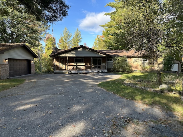 view of front of home featuring a porch, a garage, and an outbuilding